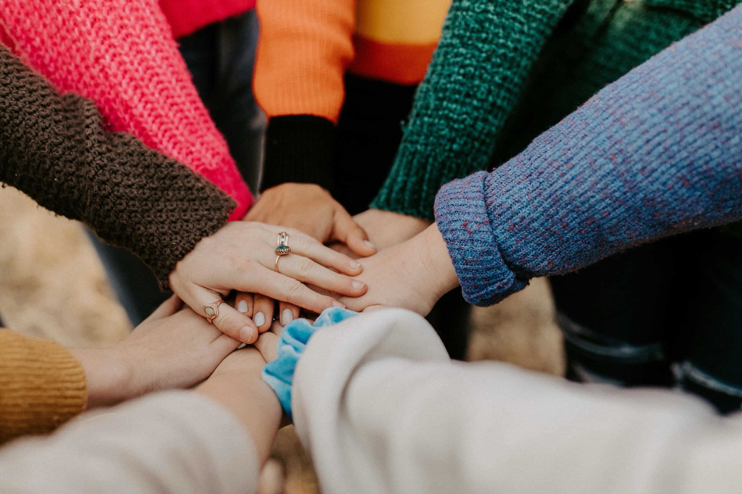Multiple people touching hands in a team building exercise